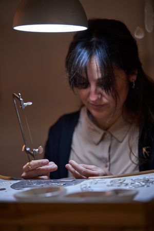 Female jeweler with saw at work