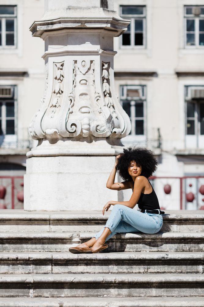 Black female siting on stairs outdoors
