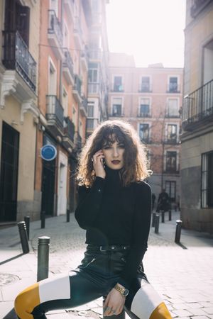 Young woman talking by phone in the street