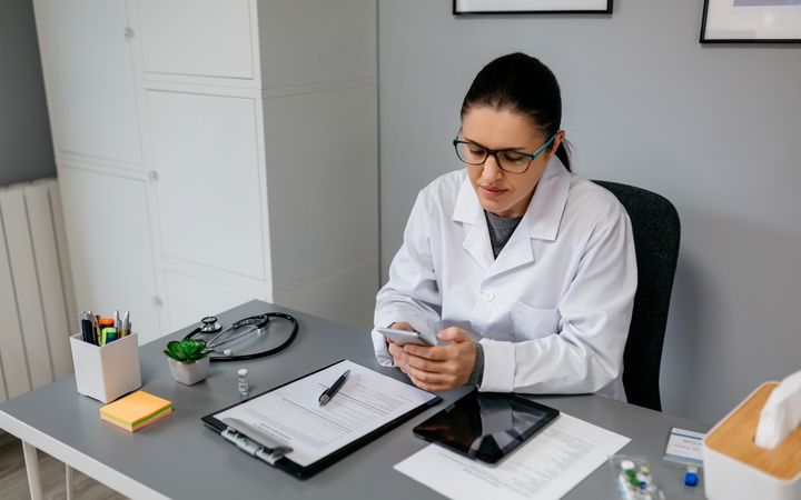 Female doctor using mobile while working