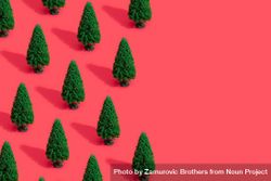 Green Christmas trees on bright salmon red background 42eYK5