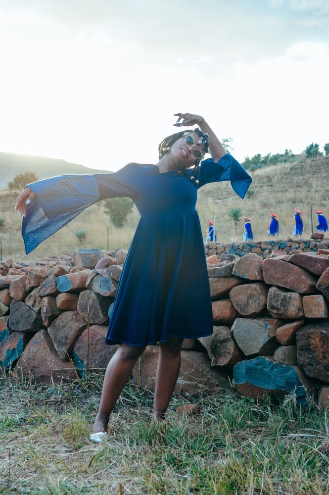 Woman poses while extending her arm and bending the other