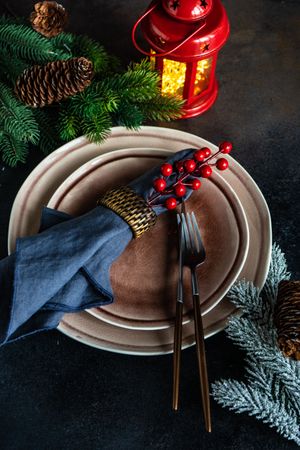 Christmas table setting with red lantern and fern