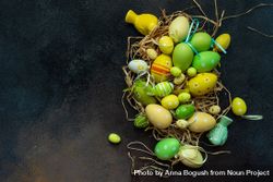 Top view of colorful Easter decorations in straw on grey table 5lVRra