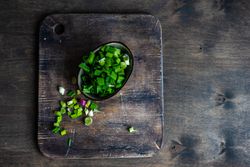 Freshly cut green onions on wooden board
