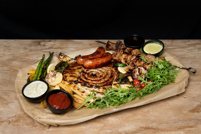 Sauces near fried meat and vegetables