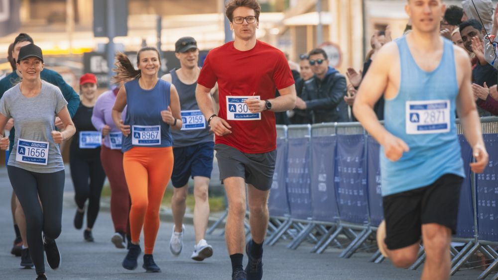 Diverse Group of People Running a Marathon in a City During the Day.