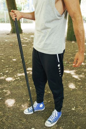 Sportsman stretching arms in park