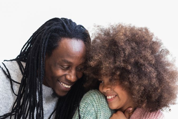 Delighted Black man cuddling with daughter