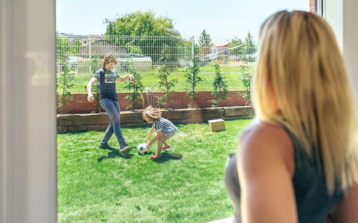 Mother watching her husband and son playing