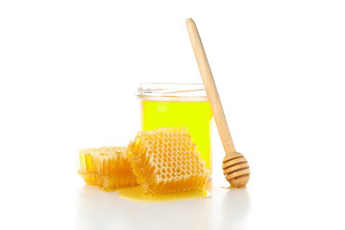 Pieces of honeycomb, glass jar and dipper isolated on plain background