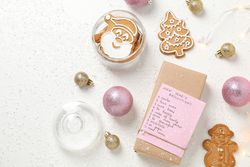Cookies and paper with list on box on plain background, top view