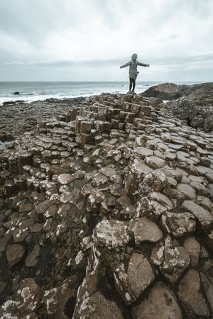 Female standing on cliff and contemplating