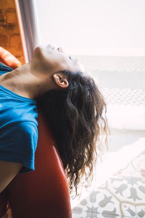 Young woman relaxing on sofa with closed eyes