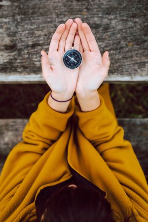 Crop woman with retro compass