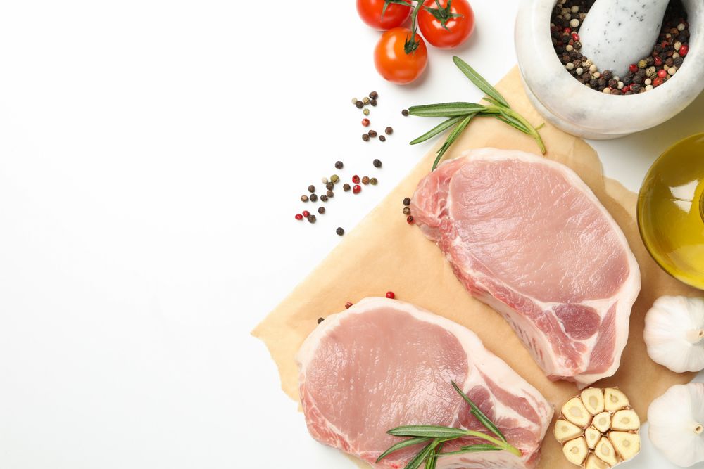 Composition with raw meat and ingredients on light background, top view