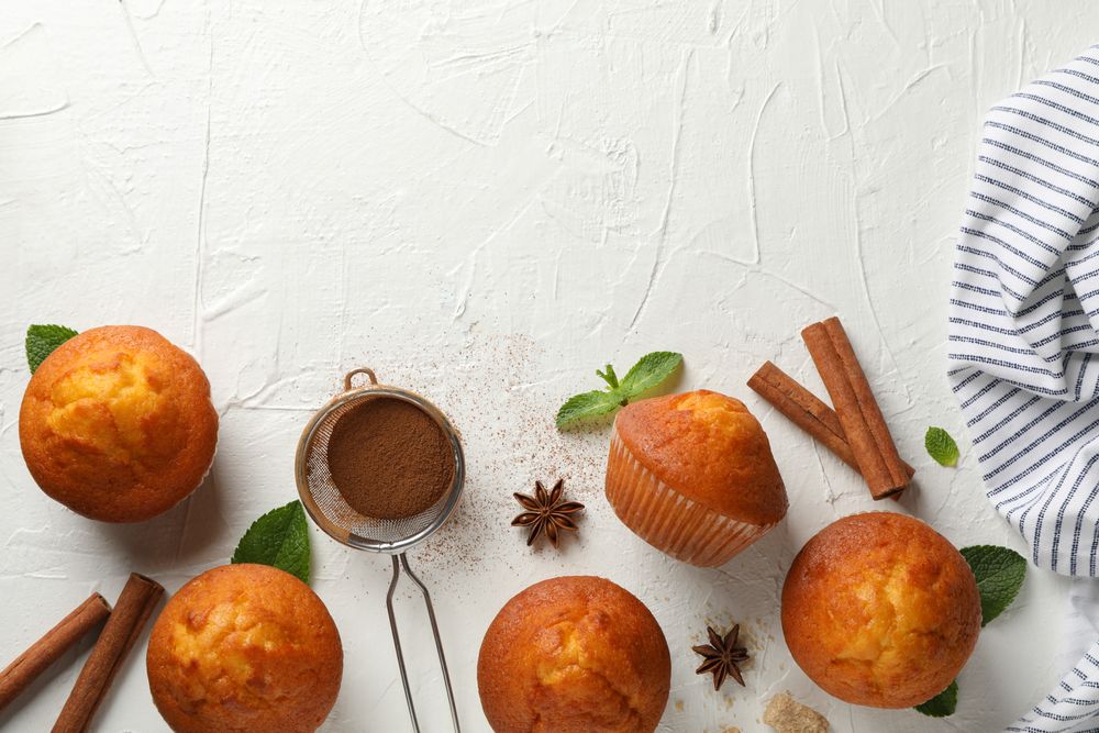 Composition with muffins and cinnamon on light background