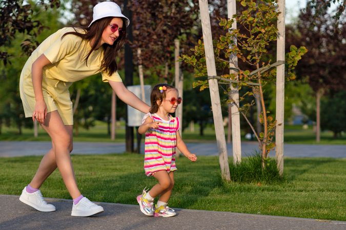 Toddler girl and mother walking hand and hand