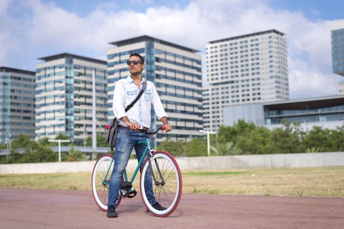 Male with colorful bicycle on city bike path