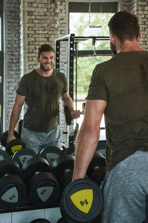 Strong man exercising with dumbbells in gym