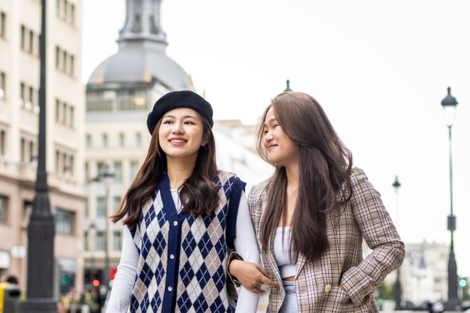 Asian young female friends walking on the street in the city