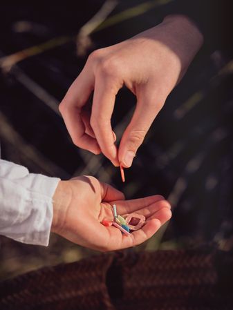 Crop person putting pieces of plastic in hand of boy