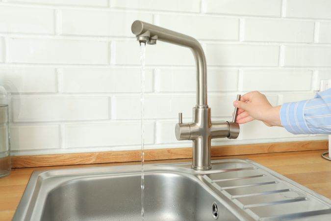 Kitchen water mixer with flowing water in kitchen room