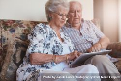 Portrait of older woman sitting with her husband and using digital tablet 5oNqQ0