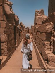 Woman walking between ancient ruins 5lrRmb