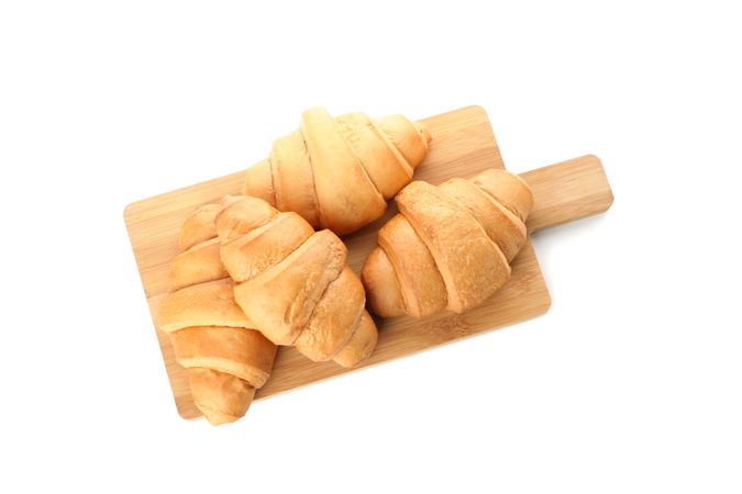 Top view of cutting board with croissants isolated on plain background