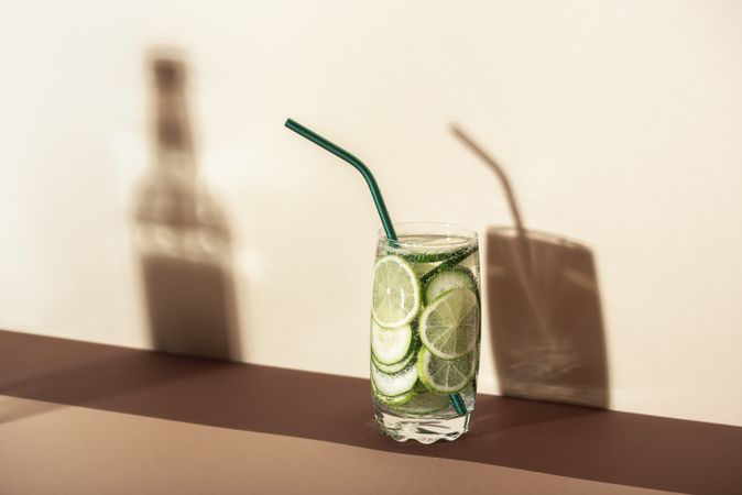 Glass of lemonade with cucumber and lime in harsh light