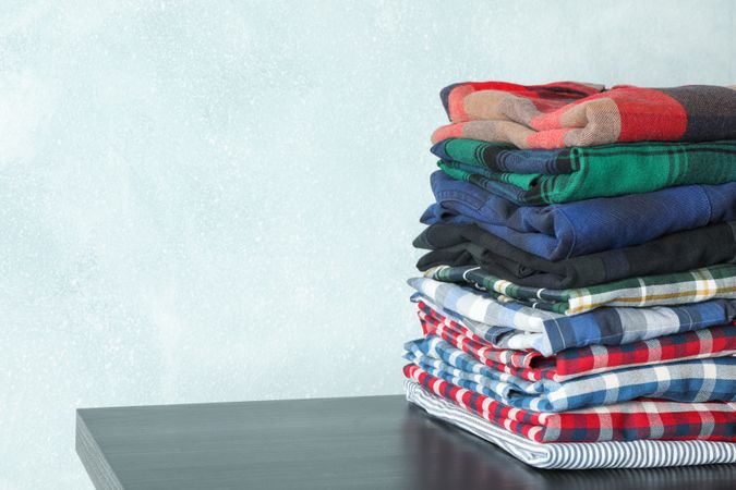 Stack of different shirts table, space for text