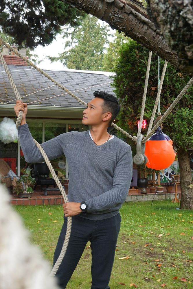 Man in gray sweater holding rope