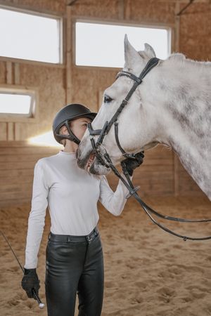 Rider with dapple gray horse in round arena