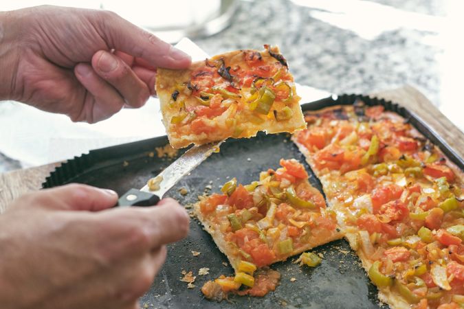 Unrecognizable person showing slice of pizza