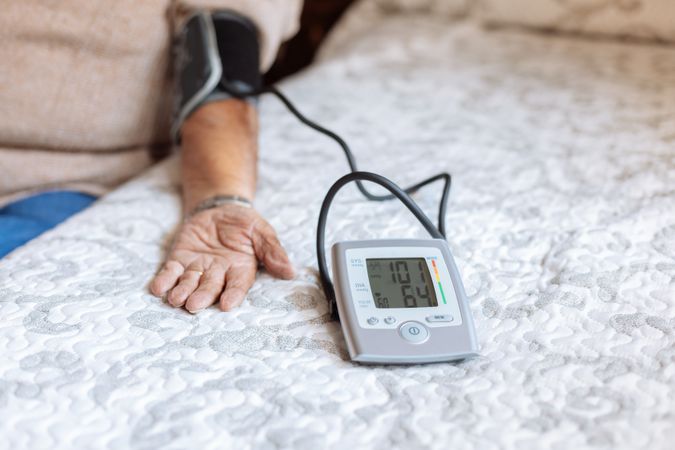 mature man checking his arterial pressure with machine