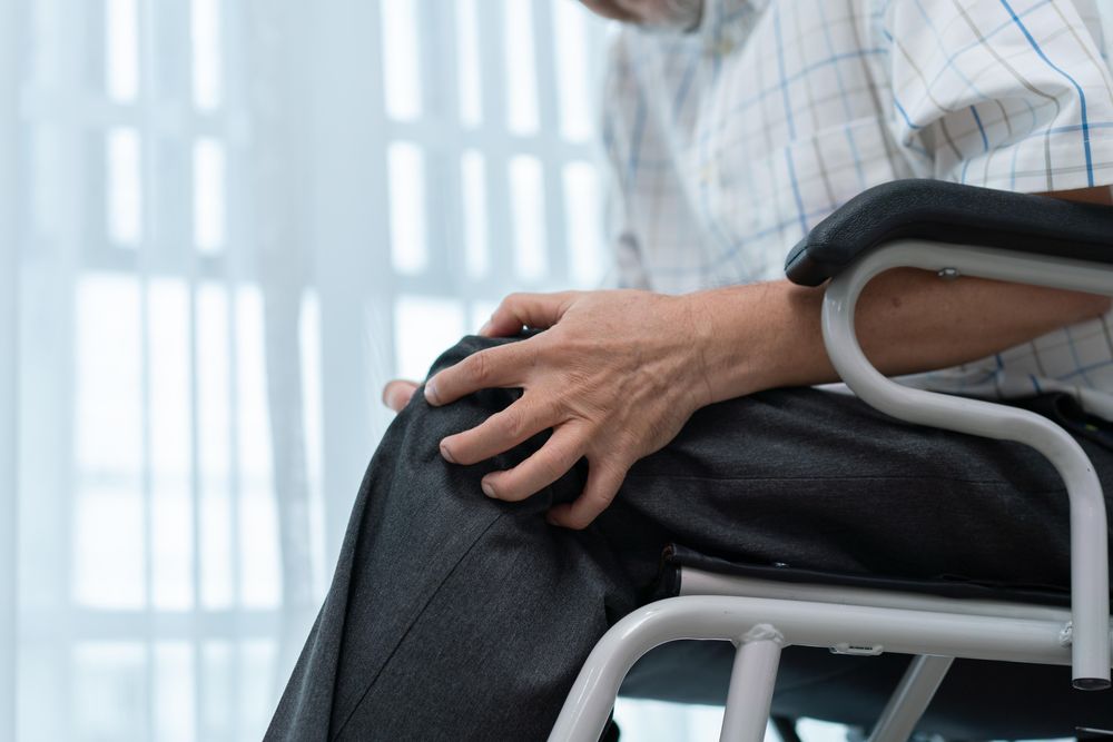 Hand grasping knee to relieve pain