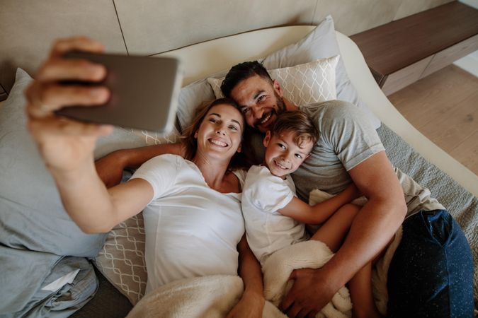 Happy woman taking selfie with her family