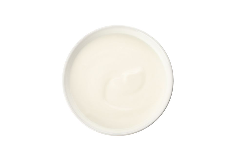 Bowl with cream yogurt isolated on light background