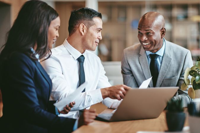 Group of people having a discussions around a laptop at an office