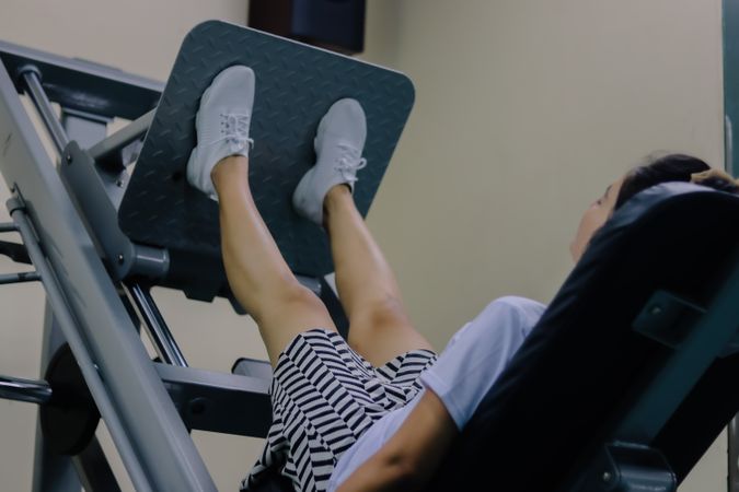 women using the leg press machine made of gray metal