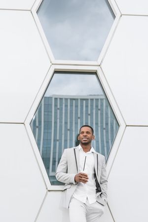 Black man with coffee standing in downtown