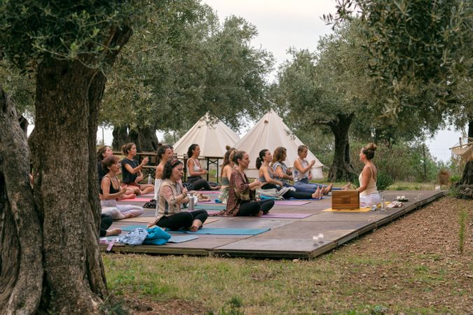 Woman meditating to music in green countryside
