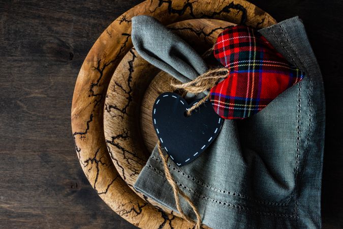 Valentine's day card concept of tartan heart decoration on rustic table setting