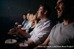 Young man watching movie with his friends in movie theater 5lPXv5