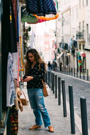 woman exploring street stall with clothes