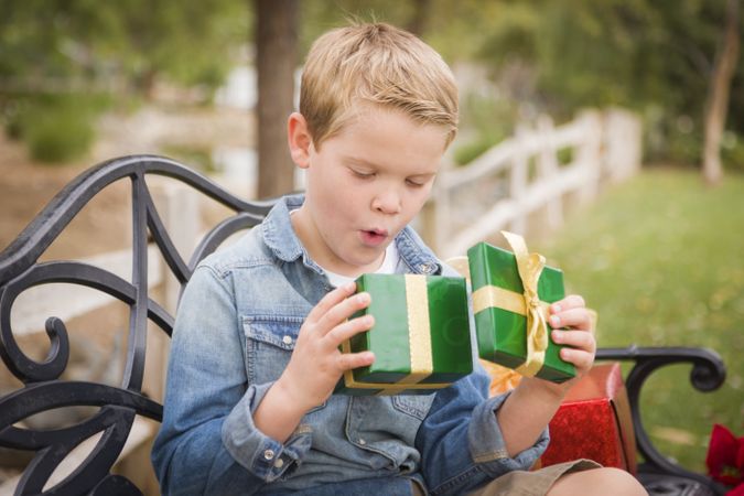 Surprised Young Boy Opens Christmas Gift Outside