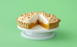 Lemon meringue cake isolated on a green background