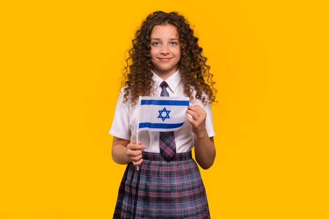 Girl in school uniform holding Israeli flag