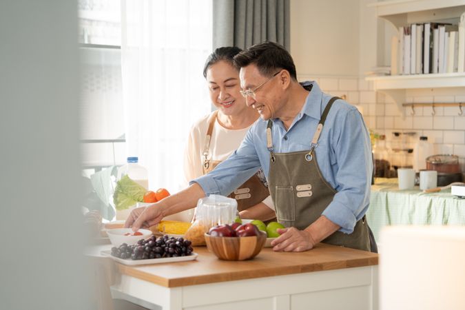 Asian couple cooking breakfast in the kitchen